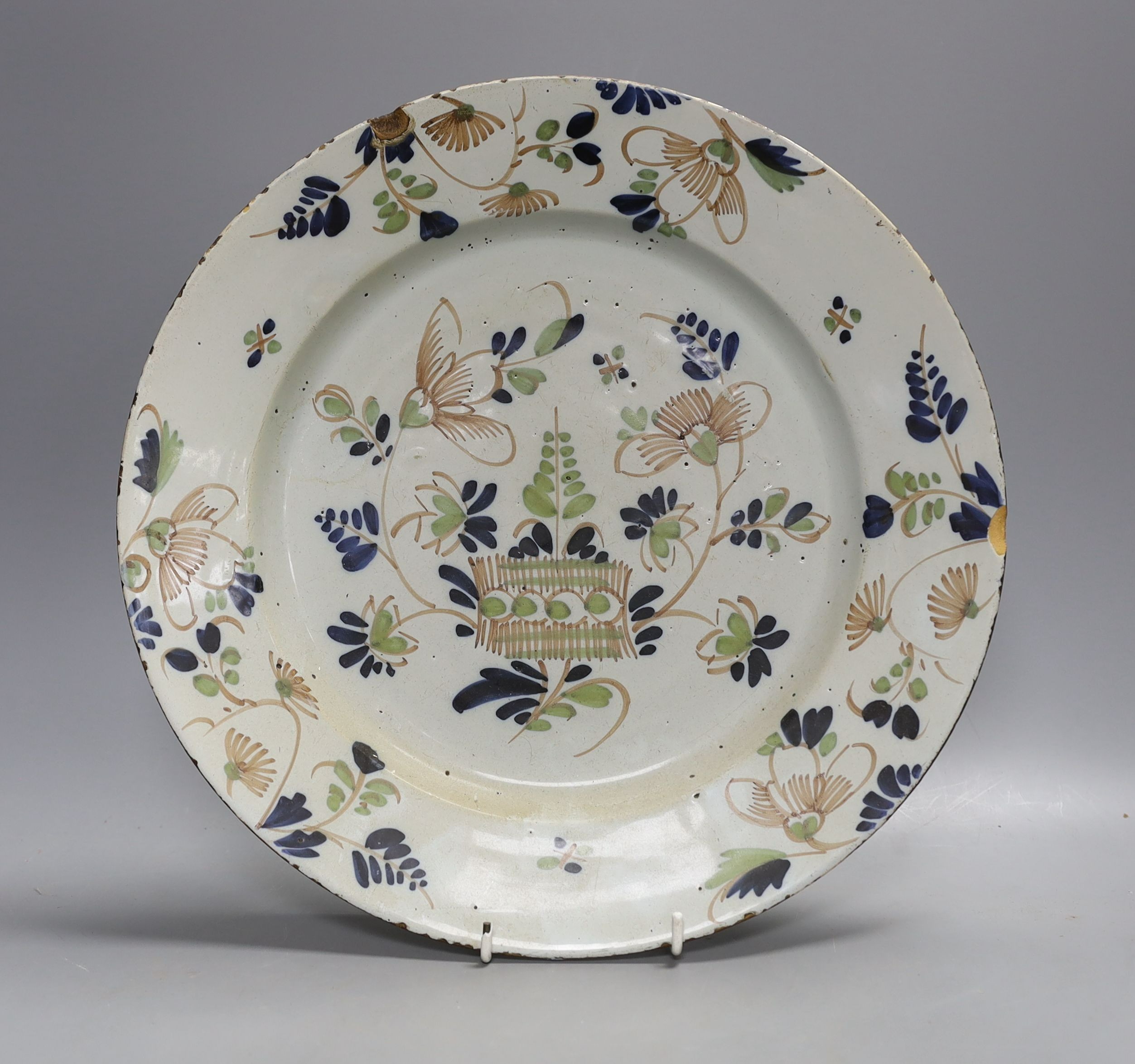 An English polychrome delftware charger, 33cms diameter.